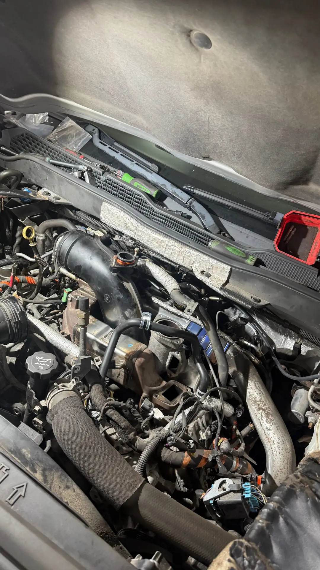 Close-up of a truck engine bay opened up for repair at The Other Guys Repair